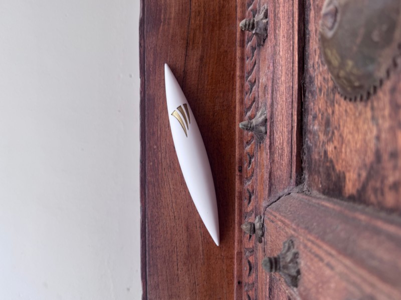 Large white Apollo mezuzah installed on wooden door frame